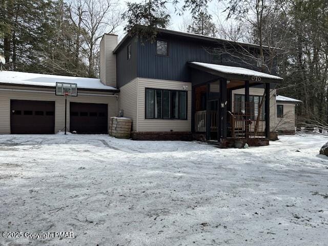 view of front of home featuring a chimney and a garage