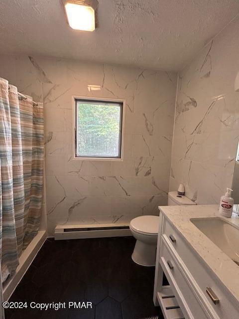 full bath with a shower stall, a textured ceiling, vanity, and a baseboard radiator