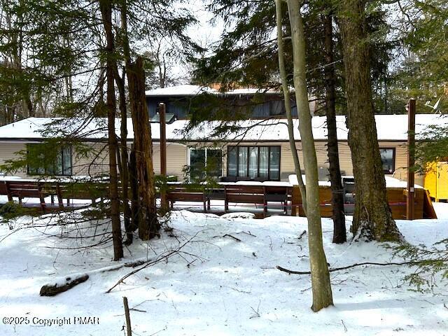 view of snow covered back of property