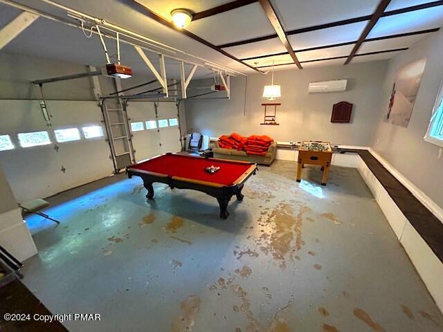 recreation room featuring billiards, a wall mounted air conditioner, a garage, and concrete flooring