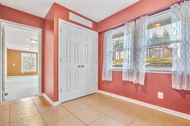 tiled entrance foyer with visible vents and baseboards