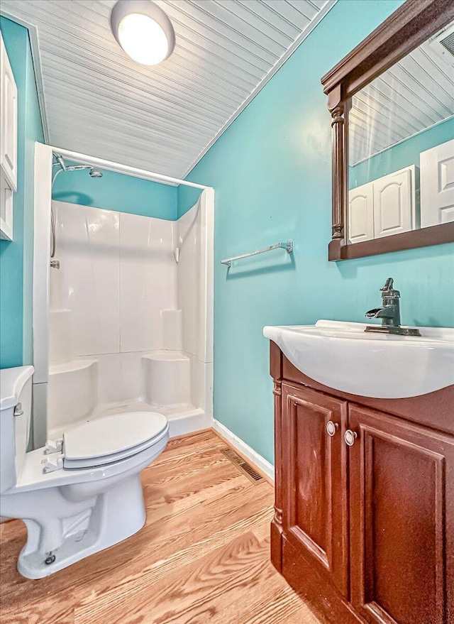 full bath with toilet, wood finished floors, a shower stall, baseboards, and vanity