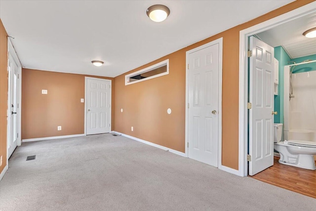 carpeted empty room with visible vents and baseboards