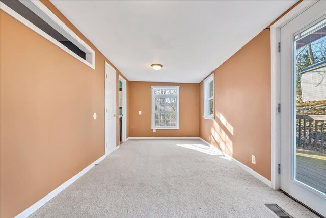 carpeted empty room featuring visible vents and baseboards