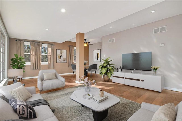 living area featuring visible vents, recessed lighting, baseboards, and wood finished floors