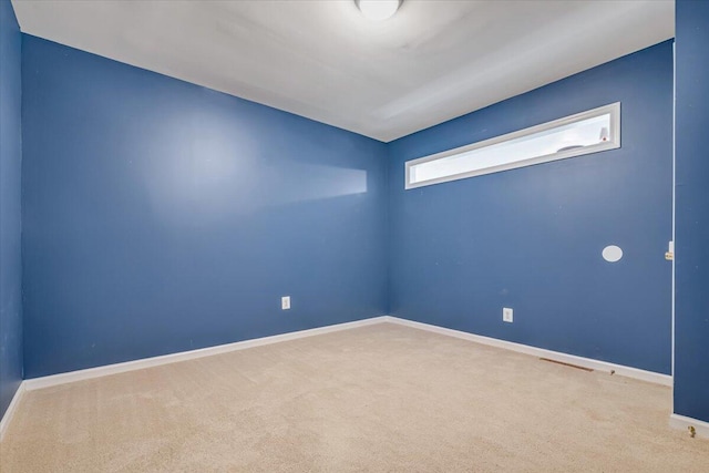 carpeted spare room featuring baseboards