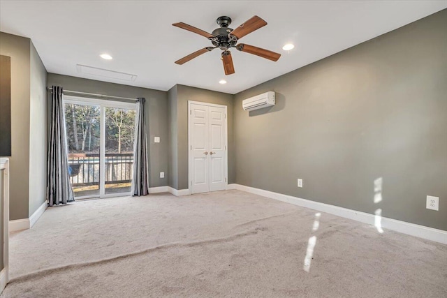 unfurnished room with an AC wall unit, recessed lighting, baseboards, and light carpet