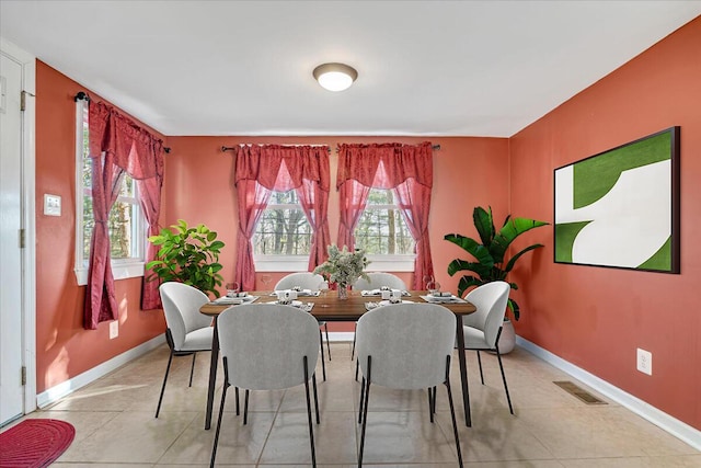 dining area with a wealth of natural light, visible vents, baseboards, and light tile patterned floors