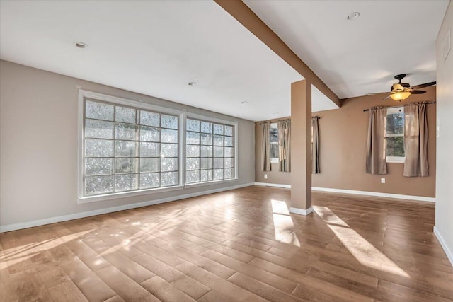 unfurnished living room with wood finished floors and baseboards