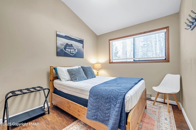 bedroom featuring baseboards, wood finished floors, and vaulted ceiling