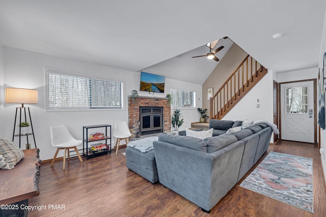 living area featuring a wealth of natural light, stairs, dark wood finished floors, and a fireplace