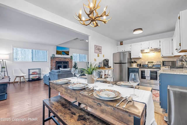 dining area featuring light wood-style flooring and a fireplace