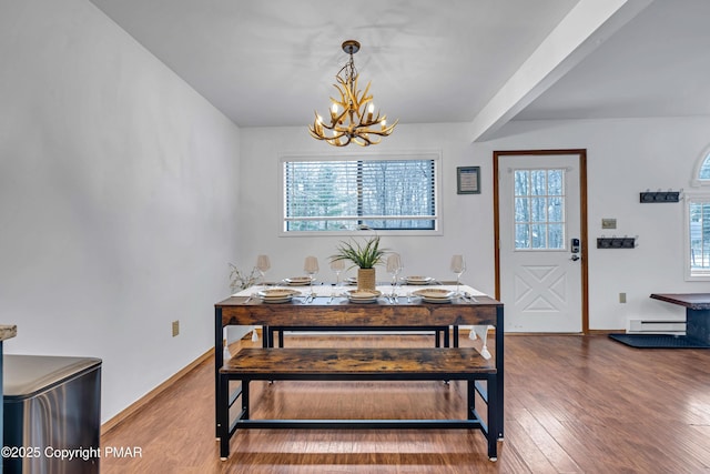 dining area with a wealth of natural light, a notable chandelier, baseboard heating, and wood finished floors