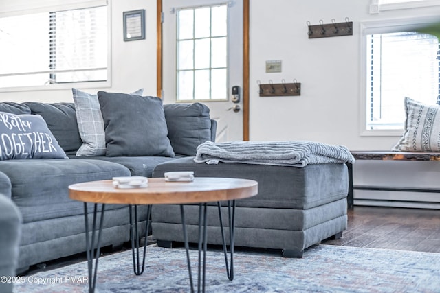 living area featuring a baseboard heating unit and wood finished floors