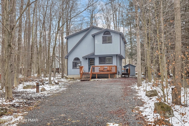 rustic home with a wooden deck and driveway