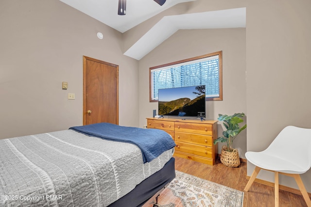 bedroom featuring lofted ceiling, a ceiling fan, baseboards, and light wood finished floors