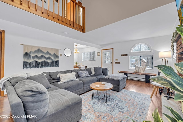 living room featuring a high ceiling, wood finished floors, and a chandelier