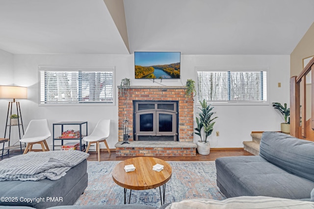 living room featuring baseboards, lofted ceiling, and wood finished floors