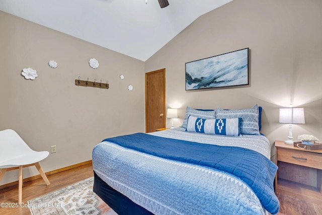 bedroom featuring ceiling fan, baseboards, wood finished floors, and vaulted ceiling