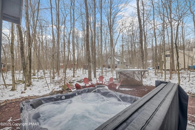 yard layered in snow featuring a hot tub