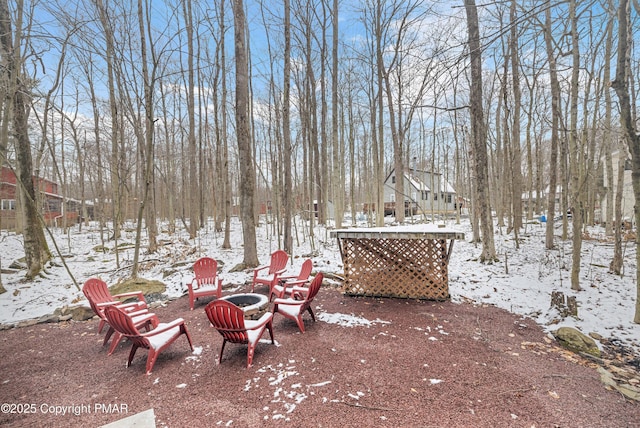 snowy yard with an outdoor fire pit