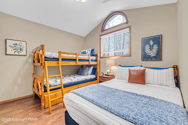 bedroom with lofted ceiling, wood finished floors, and baseboards