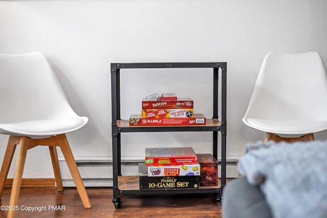 interior details with baseboard heating and wood finished floors