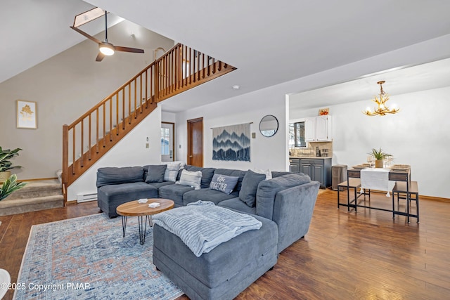 living area with stairway, plenty of natural light, dark wood finished floors, and a baseboard radiator