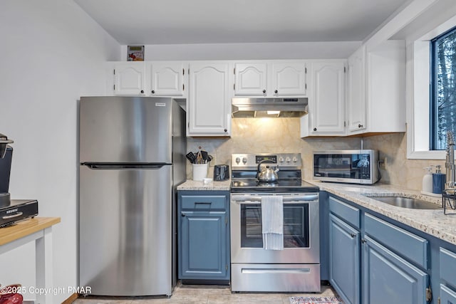 kitchen featuring under cabinet range hood, blue cabinets, appliances with stainless steel finishes, and white cabinetry