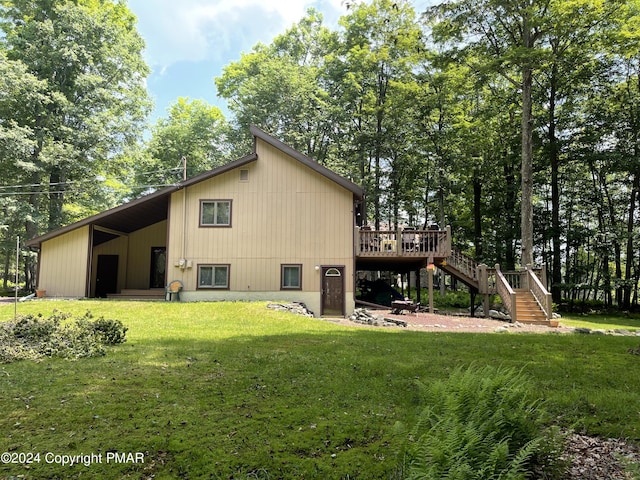 back of house with stairs, a yard, and a deck