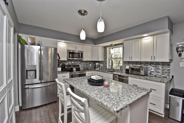 kitchen with dark wood-style flooring, a sink, stainless steel appliances, decorative backsplash, and white cabinetry