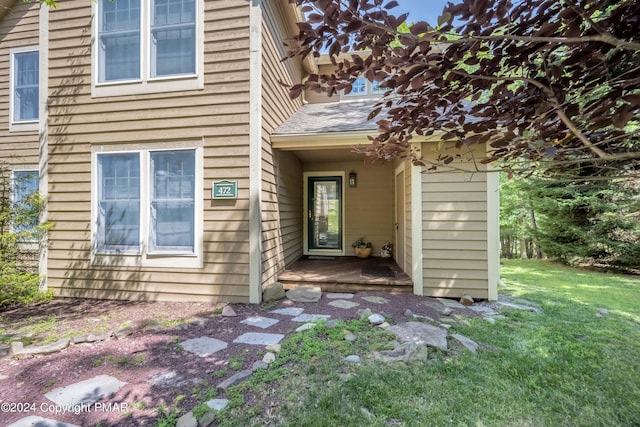 entrance to property featuring a lawn