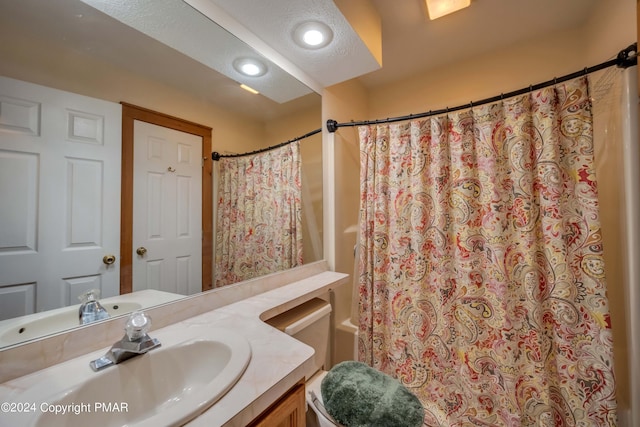 bathroom featuring toilet, vanity, shower / bath combo with shower curtain, recessed lighting, and a textured ceiling