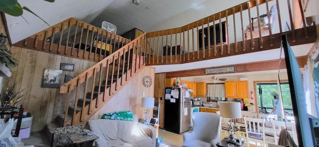 195 Bellingham Dr, Bushkill, PA 18324 - living room with ceiling fan, high vaulted ceiling, wooden walls, and stairway