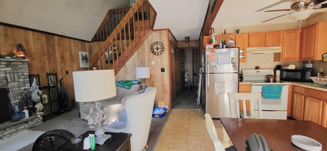195 Bellingham Dr, Bushkill, PA 18324 - kitchen with freestanding refrigerator, electric range, under cabinet range hood, black microwave, and wooden walls