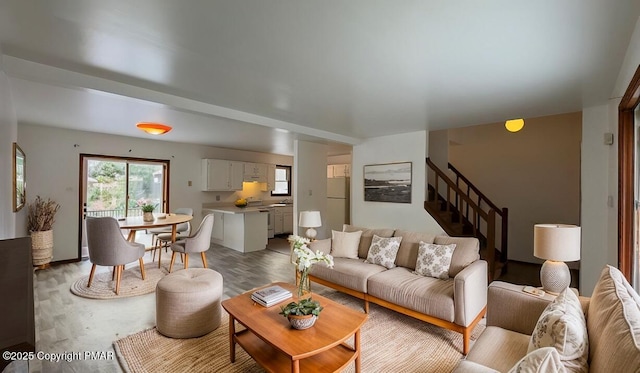 living room featuring light wood-style flooring and stairs