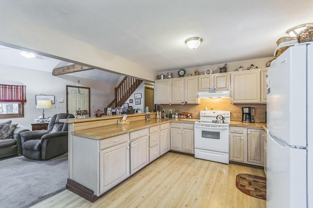 kitchen featuring exhaust hood, a peninsula, open floor plan, white appliances, and light wood-style flooring