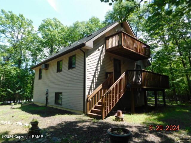 view of side of property with a balcony and stairway