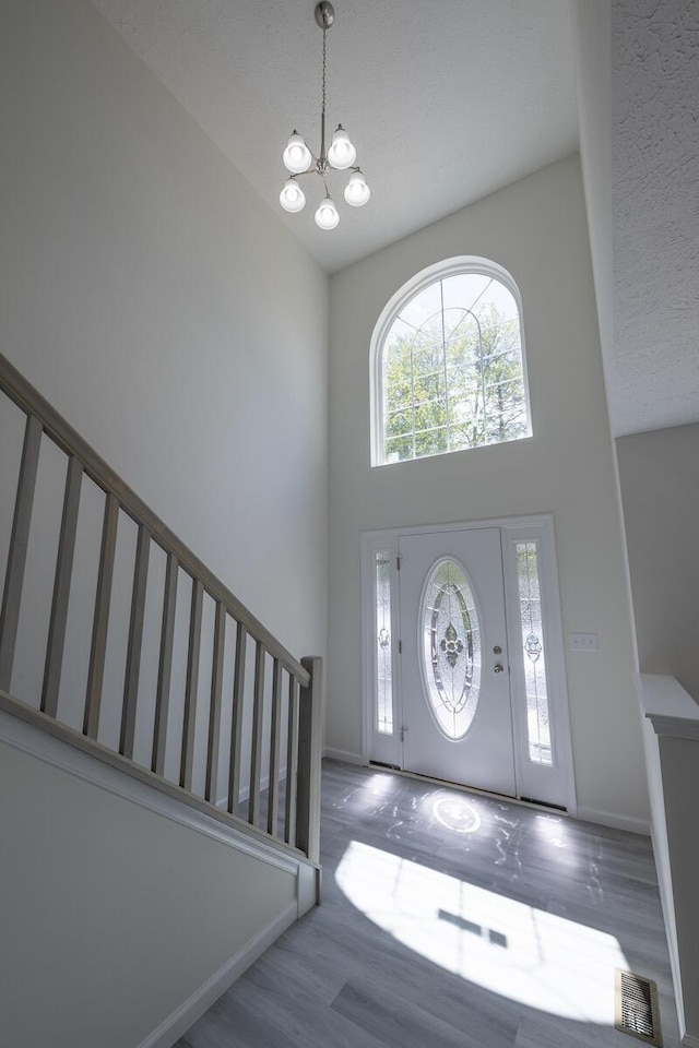 9133 Belvedere Rd # 5020, Tobyhanna, PA 18466 - entryway with a chandelier, a high ceiling, wood finished floors, stairs, and baseboards