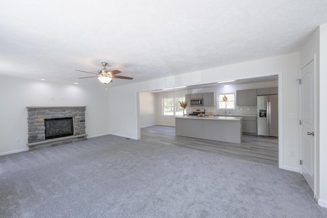 9133 Belvedere Rd # 5020, Tobyhanna, PA 18466 - unfurnished living room with light colored carpet, ceiling fan, baseboards, and a textured ceiling