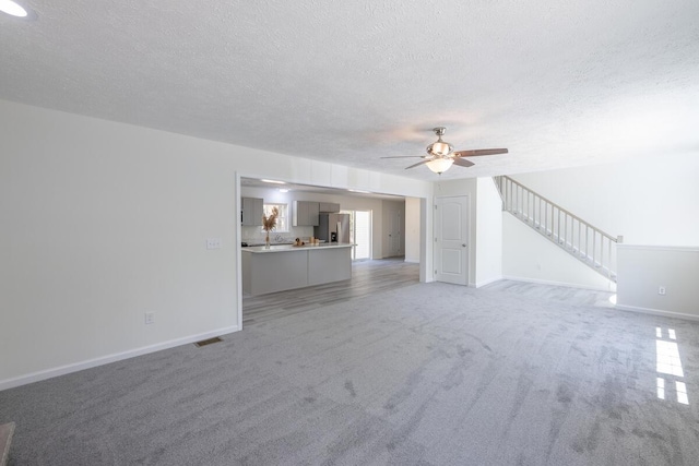9133 Belvedere Rd # 5020, Tobyhanna, PA 18466 - unfurnished living room with a textured ceiling, light carpet, a ceiling fan, and baseboards