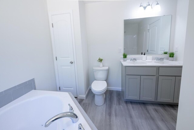 9133 Belvedere Rd # 5020, Tobyhanna, PA 18466 - bathroom with double vanity, a bath, toilet, and wood finished floors