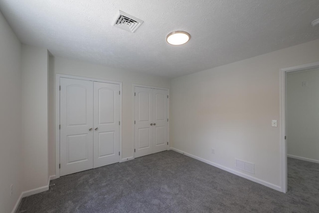 9133 Belvedere Rd # 5020, Tobyhanna, PA 18466 - unfurnished bedroom with carpet flooring, baseboards, multiple closets, and a textured ceiling