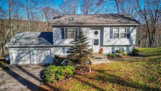 split foyer home with a garage, driveway, and a shingled roof