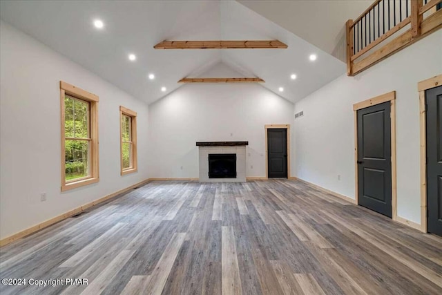 unfurnished living room featuring wood finished floors, baseboards, high vaulted ceiling, recessed lighting, and a fireplace