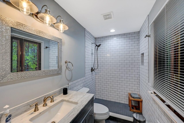 3207 Green Meadow Cir, Pocono Pines, PA 18350 - bathroom featuring toilet, tiled shower, vanity, and tile walls