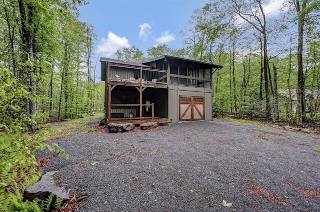 3207 Green Meadow Cir, Pocono Pines, PA 18350 - view of front facade with a sunroom, a wooden deck, a wooded view, and driveway