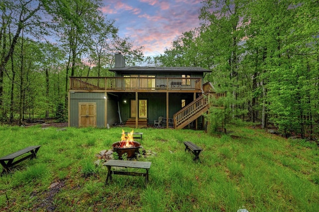 3207 Green Meadow Cir, Pocono Pines, PA 18350 - back of property at dusk with a fire pit, a wooden deck, a chimney, and stairs