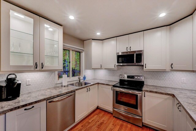 3207 Green Meadow Cir, Pocono Pines, PA 18350 - kitchen with stainless steel appliances, a sink, light wood-style floors, decorative backsplash, and recessed lighting