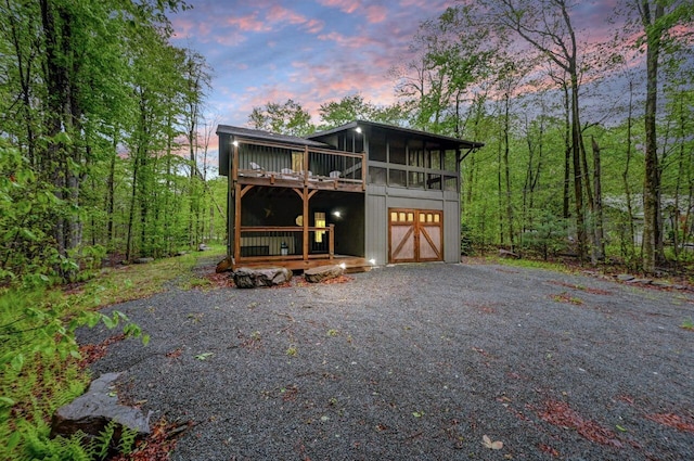 3207 Green Meadow Cir, Pocono Pines, PA 18350 - view of front of home featuring a sunroom, a deck, driveway, and an attached garage
